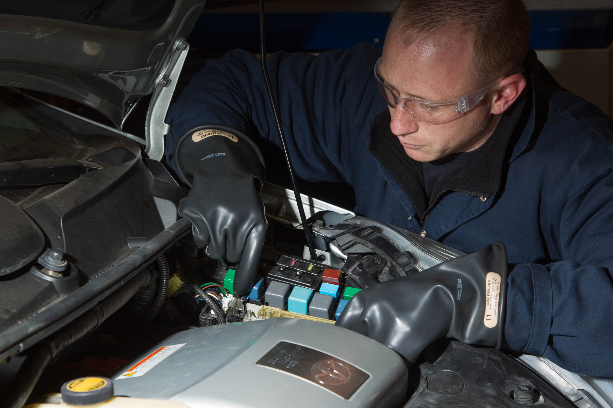 Man looking under the hood of a car