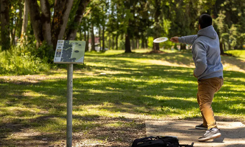 A disc golf player throws from the 10th hole tee box on the Chemeketa disc golf course